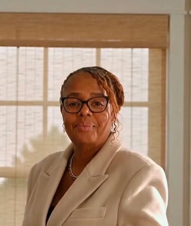 Deon in a cream blazer, warm natural light